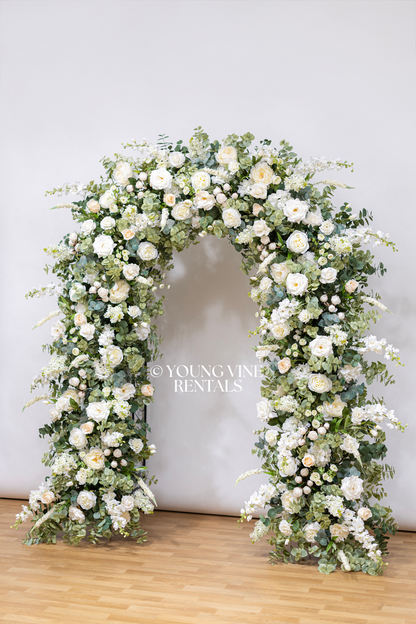 Lush, romantic, U-shaped wedding arbor studded with an abundance of ivory and white flowers and various types of eucalyptus foliage.